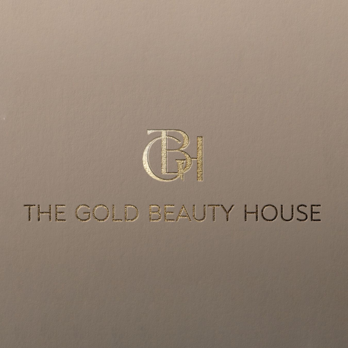 Het visitekaartje van The Gold Beauty House: het GBH-monogram en de naam in goudfolie op taupe papier